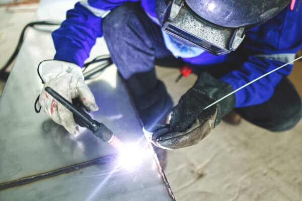 Welder wearing safety gear working on a weld.